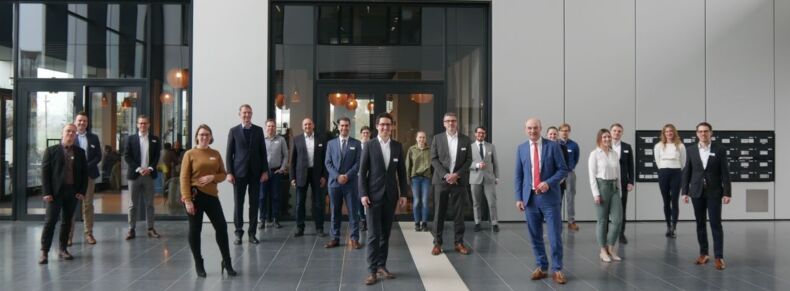 Das Bild zeigt Teilnehmende des Kick-Off Workshop zum Konsortial-Benchmarking „Circular Economy – Lifecycle-Management in produzierenden Unternehmen“. Zwanzig Personen stehen mit Abstand zueinander in einer Eingangshalle.
